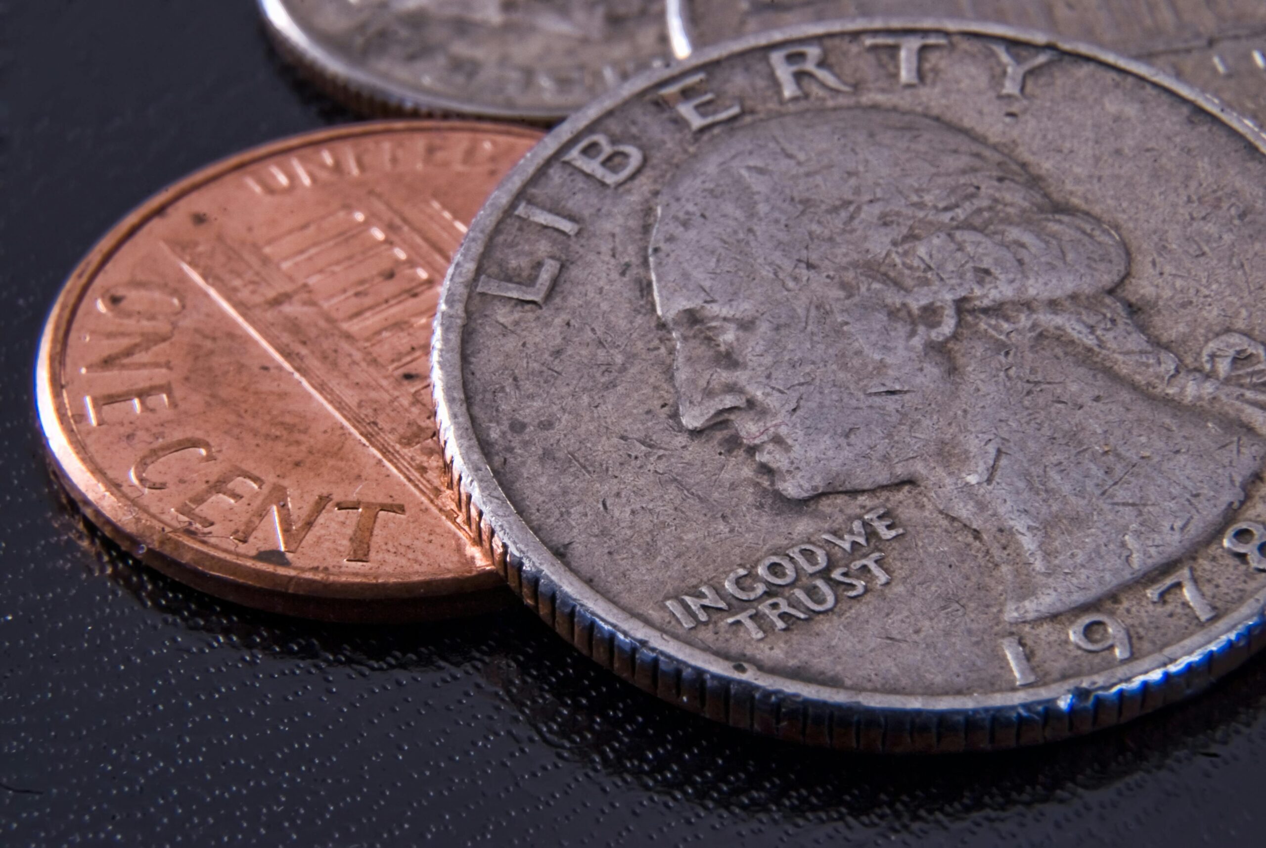 Detailed close-up of a US quarter and penny highlighting currency texture.